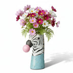 photo du vase zèbre sur fonds blanc avec des cosmos roses