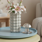 Photo du vase Lys à boules en ceramique sur une table gigogne bleue et une autre jaune en dessous