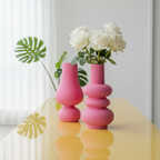 Image de vase en verre rose posés sur une table jaune