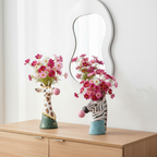Photos des vases zebre et girafe sur un meuble en bois avec un miroir derrière