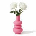 image du vase rose en verre avec une forme de donuts empilés