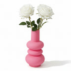image du vase rose en verre avec une forme de donuts empilés